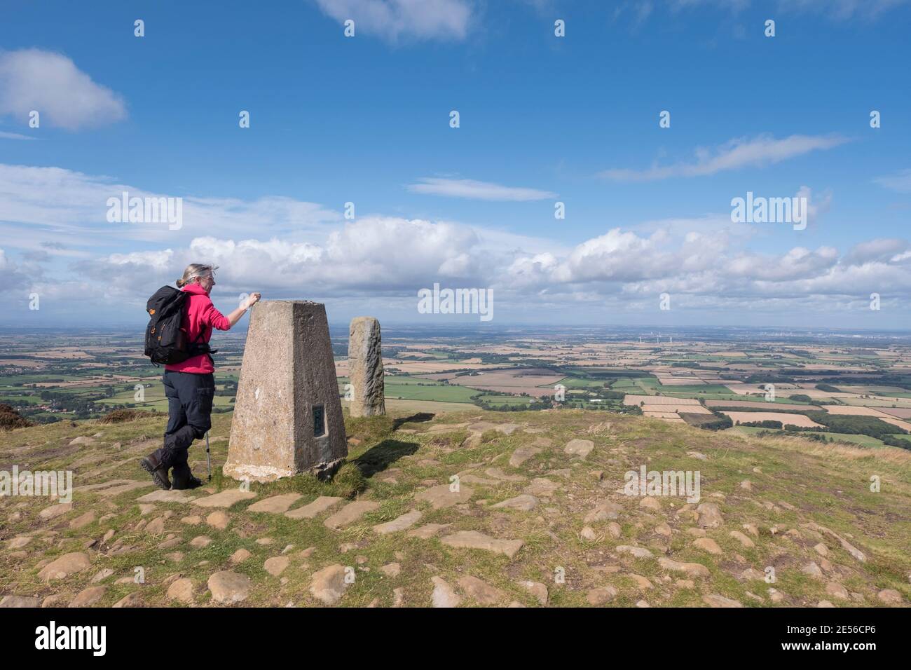 A female hillwalker at the trig point on Carlton Bank in the North York Moors. Stock Photo