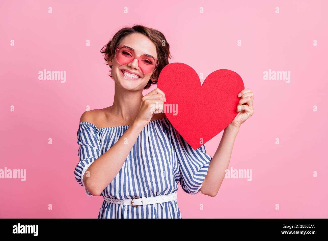 Photo portrait of cute girl holding big red heart card with two hands ...