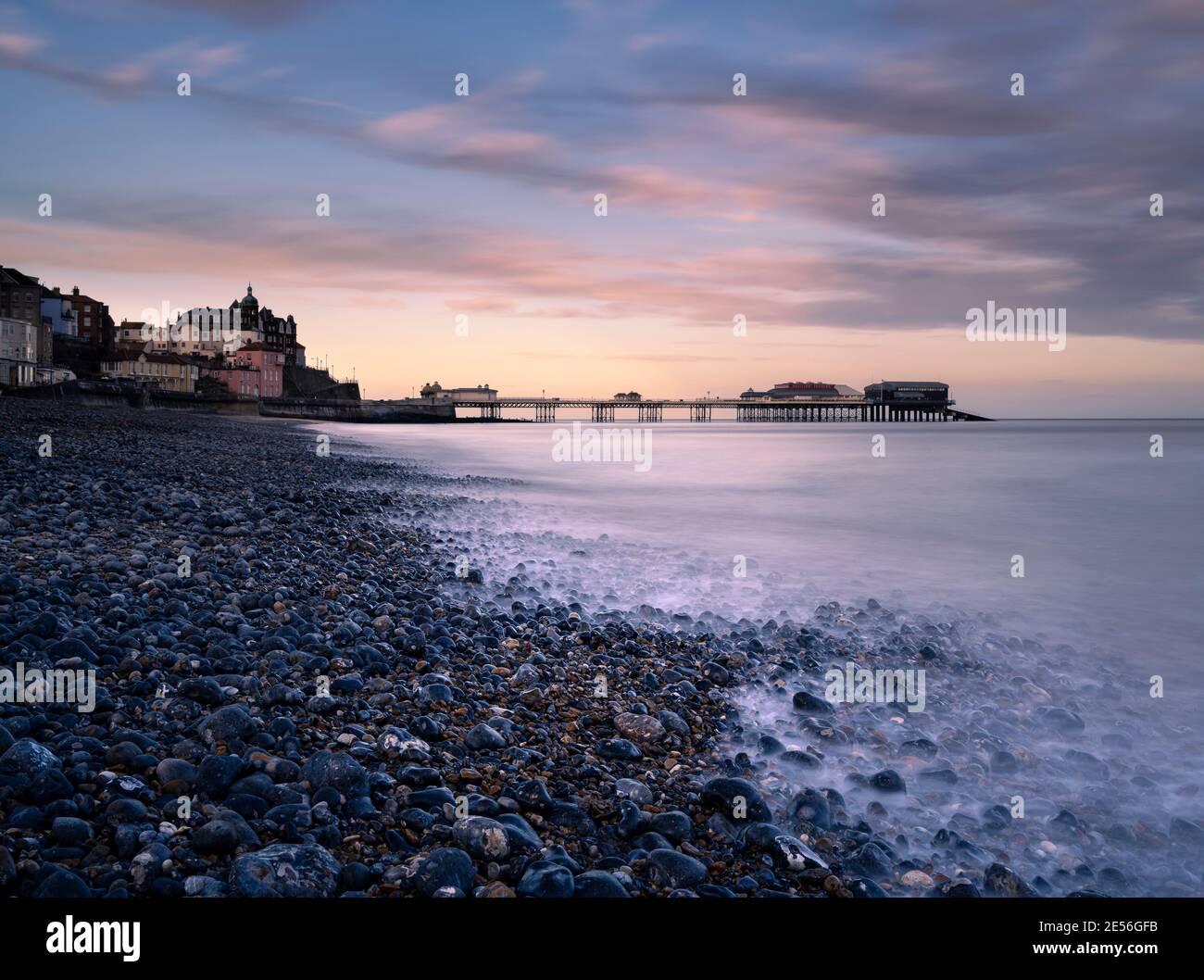Cromer Pier and the pebbles on the beach at sunrise. Stock Photo