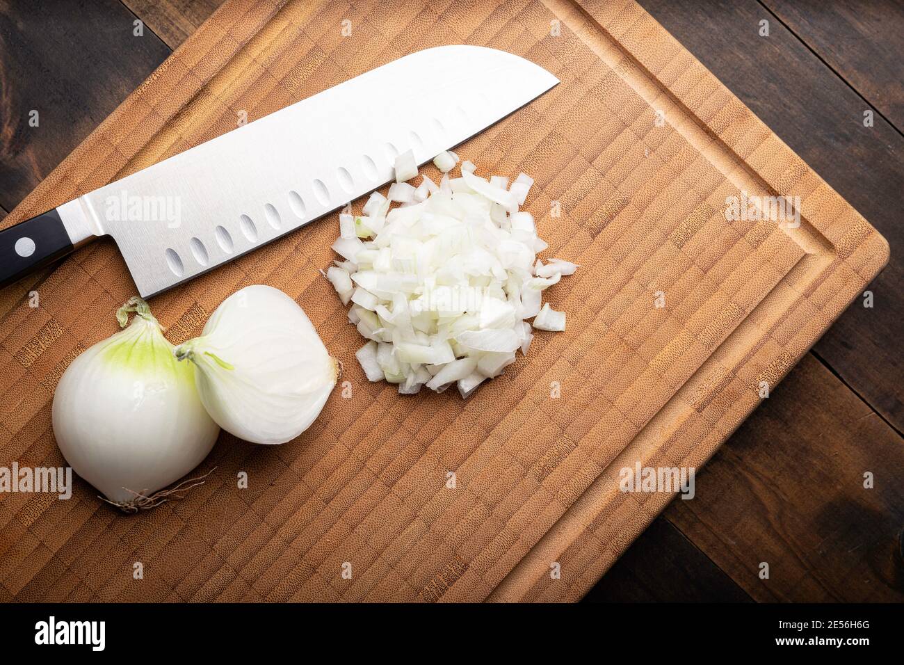 Fresh diced white onion on bamboo cutting board. Allium cepa. wooden background Stock Photo