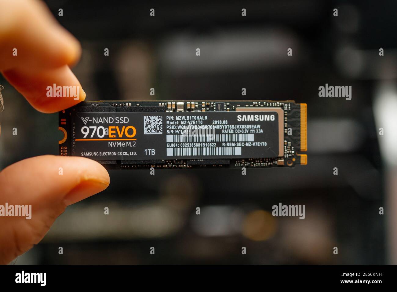London, United Kingdom - Jan 18, 2019: POV personal perspective male hand  holds new M2 connector the new Samsung NVME V-Nand SSD Samsung 970 disk  with one terabyte storage space compter background