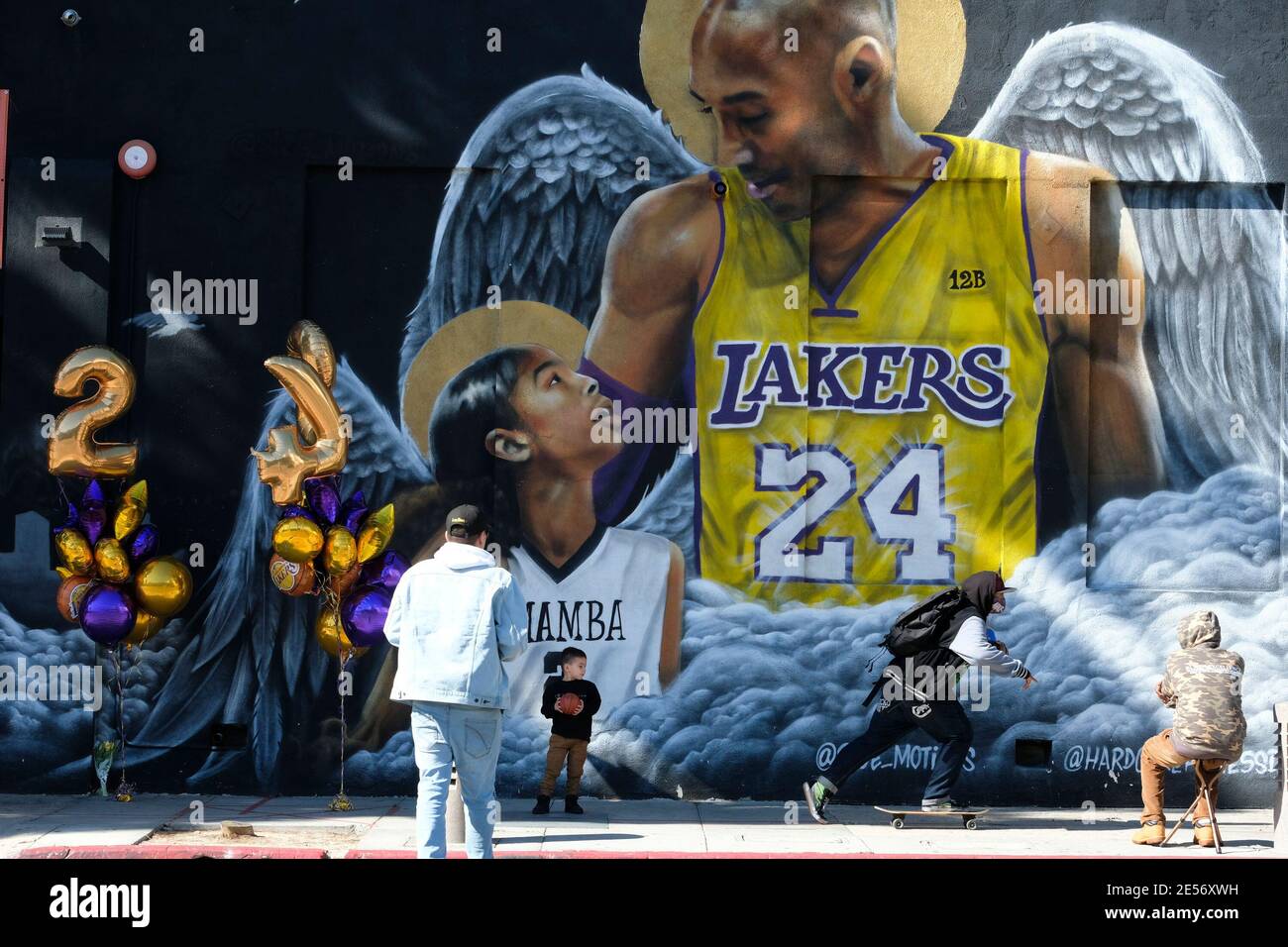Los Angeles, California, USA. 26th Jan, 2021. A man and a kid take pictures in front of a mural honoring NBA star Kobe Bryant and his daughter Gigi near Staples Center in downtown Los Angeles, Tuesday, Jan. 26, 2021. Credit: Ringo Chiu/ZUMA Wire/Alamy Live News Stock Photo