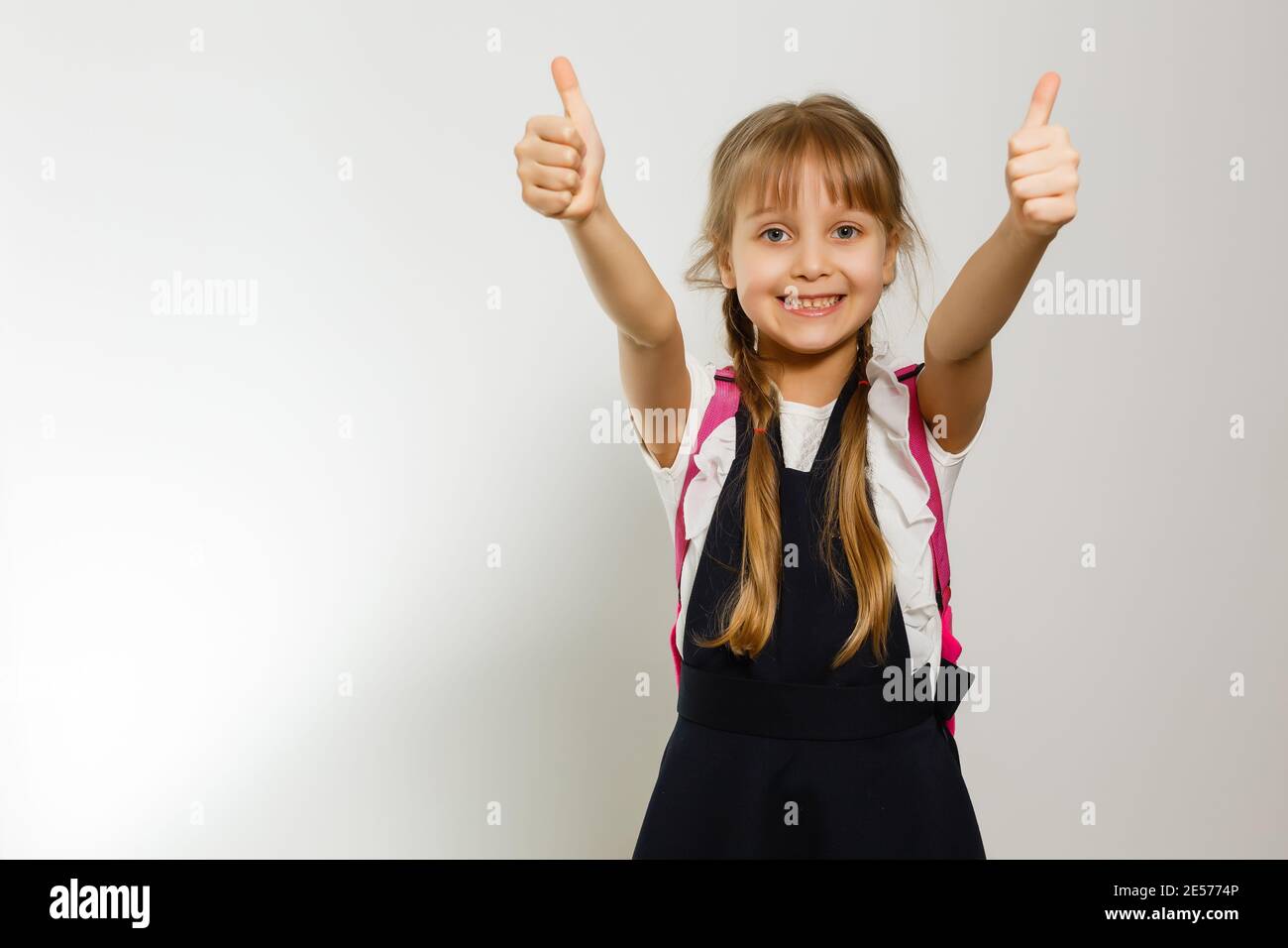 Cute smiling schoolgirl in uniform standing on white background Stock ...