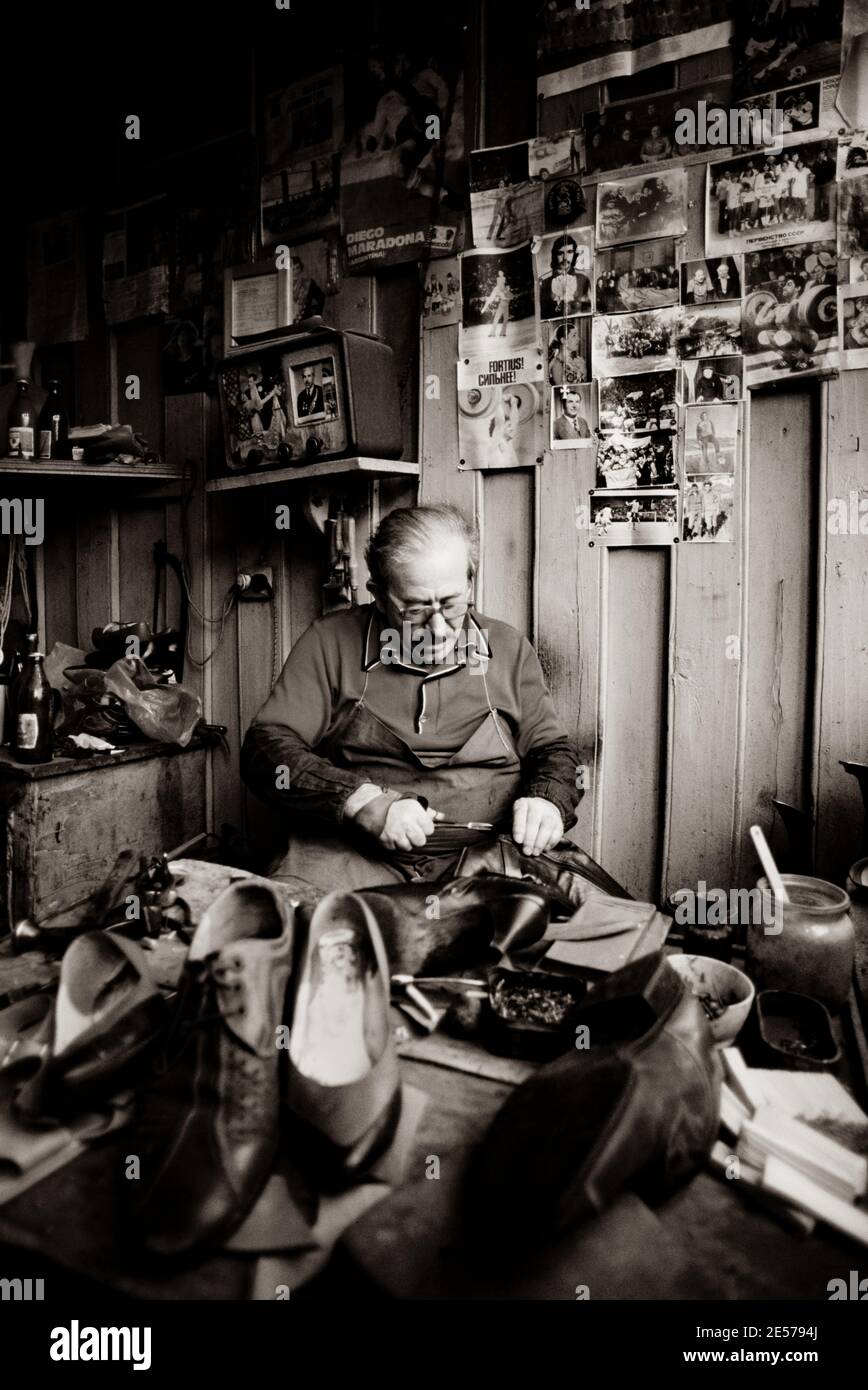 A cobbler works in his shop in Tbilisi, Soviet Georgia - 1990 Stock Photo