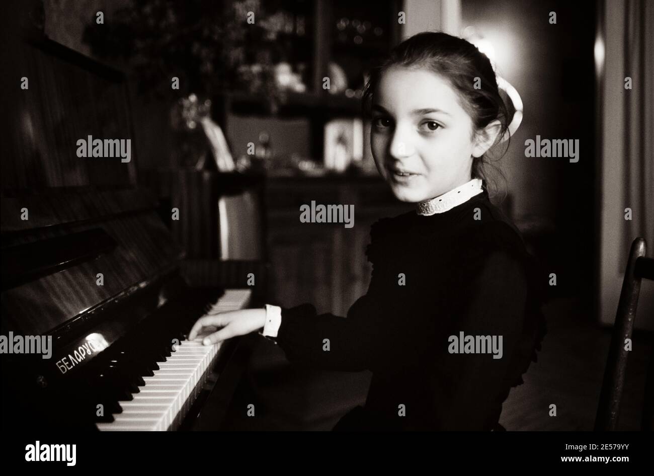 A young Georgian girl practices classical piano in her parents apartment in Tbilisi, Soviet Georgia . 1990 Stock Photo