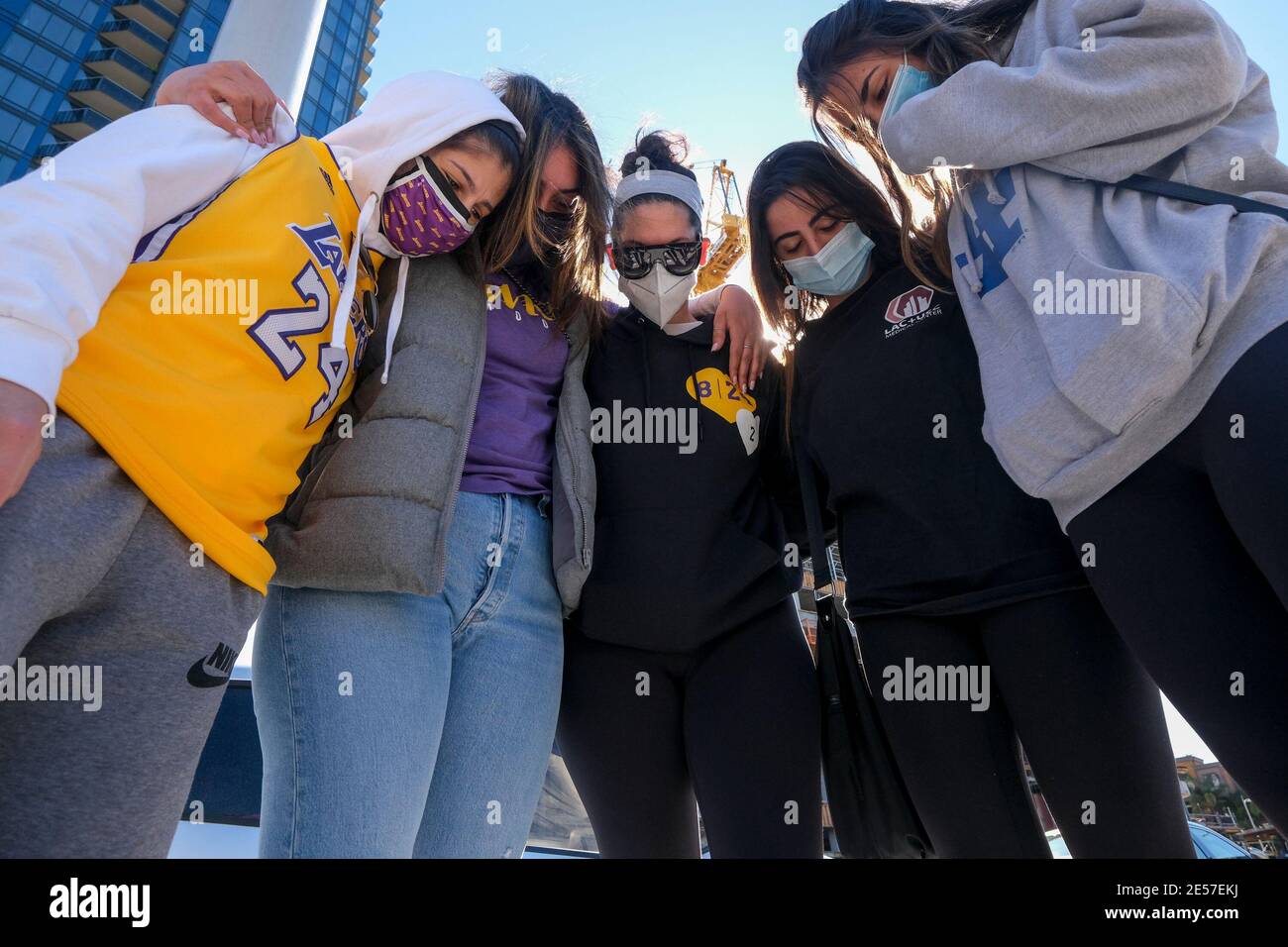 Los Angeles, California, USA. 26th Jan, 2021. Fans pray in front of a makeshift memorial honoring NBA star Kobe Bryant and his daughter Gigi near Staples Center in downtown Los Angeles, Tuesday. Credit: Ringo Chiu/ZUMA Wire/Alamy Live News Stock Photo