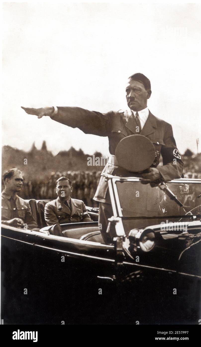 1930 's , Germany : The Nazi dictator ADOLF  HITLER ( 1889 - 1945 ) during a military parade , seated in car ( at left ) RUDOLF HESS ( 1894 - 1987 )  with the Jugendfuhrer  BALDUR VON SCHIRACH ( 1907 - 1974 ).  - NAZISMO - NAZISTI - NAZISTA - NAZISM - NAZIST - WWII - WORLD WAR 2nd - WW II - SECONDA GUERRA MONDIALE - DITTATORE - automobile - car - parata - tie - cravatta - collar - colletto - military uniform - uniforme divisa militare - baffi - moustache - saluto - salutation - svastica ----    Archivio GBB Stock Photo