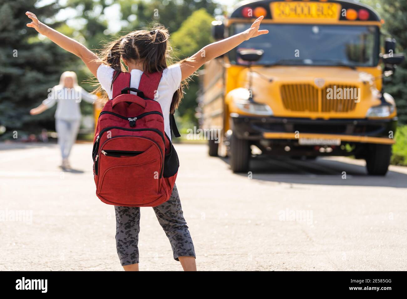 Beautiful small girl with mother near school Stock Photo - Alamy