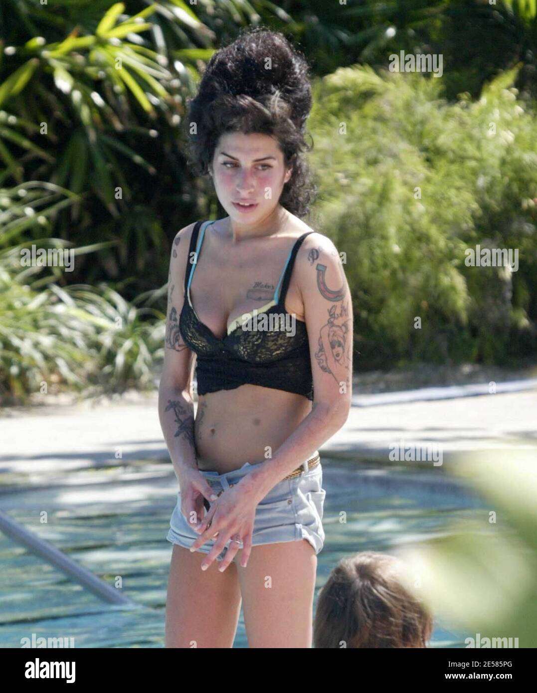 Rehab" singer Amy Winehouse displayed her tattoos and scars in a skimpy  pair of shorts and lacy top as she chilled out at a Miami Beach hotel pool  amid rumors that she