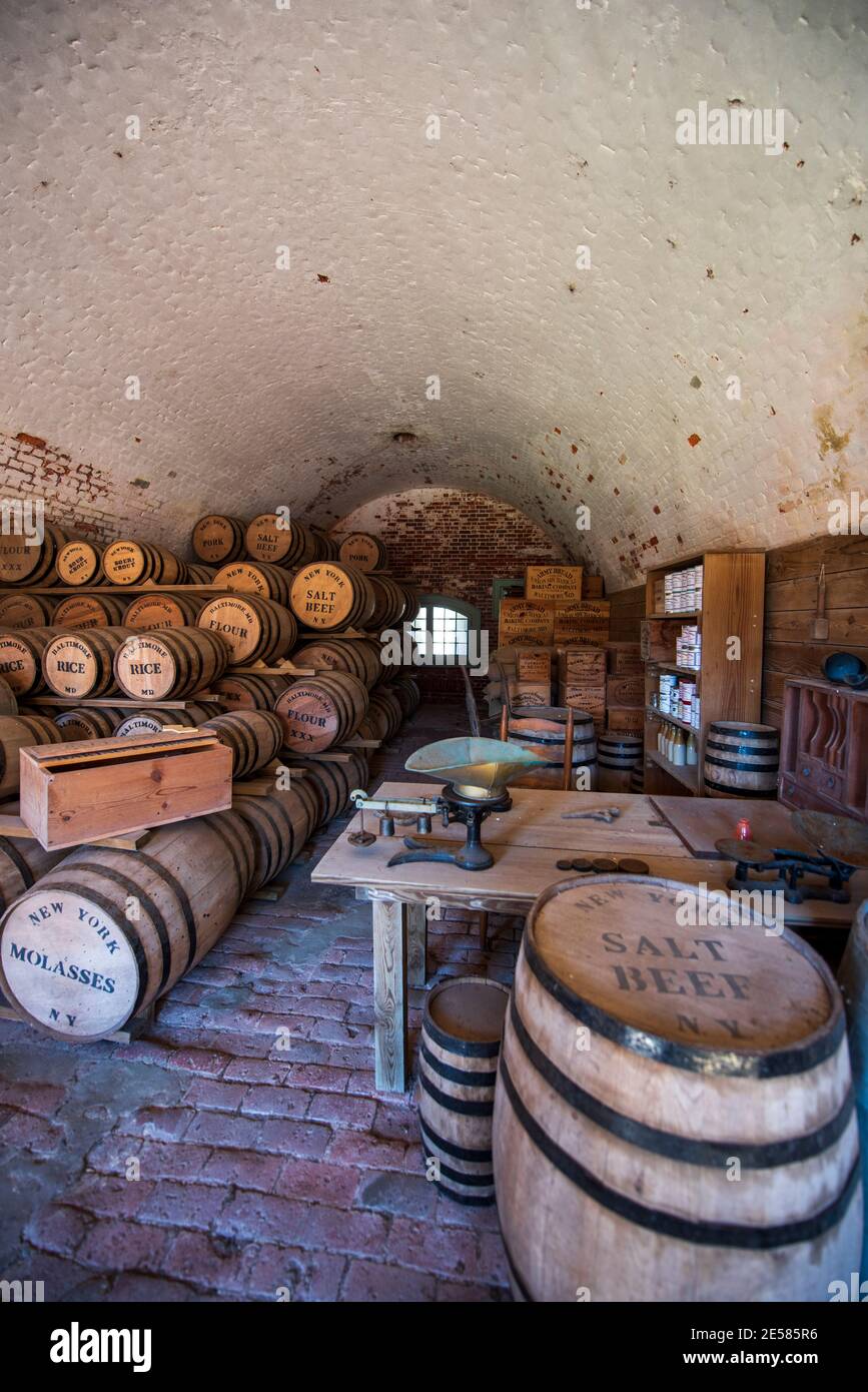 Barrels labeled 'vinegar, salt beef, rice, flour, salt, molasses, pickled onions  and coffee' fill a recreated ration storage room at Fort Macon State Stock Photo