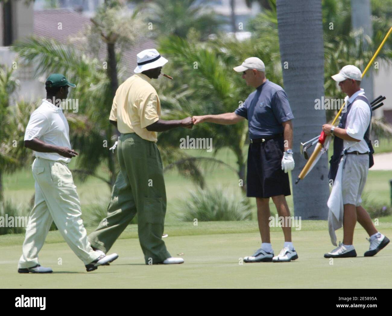 Exclusive!! NBA legend Michael Jordan takes time out to enjoy a game of  golf with friends. He puffed on a stogie throughout and started slicing  badly when he spied our snapper. Miami,