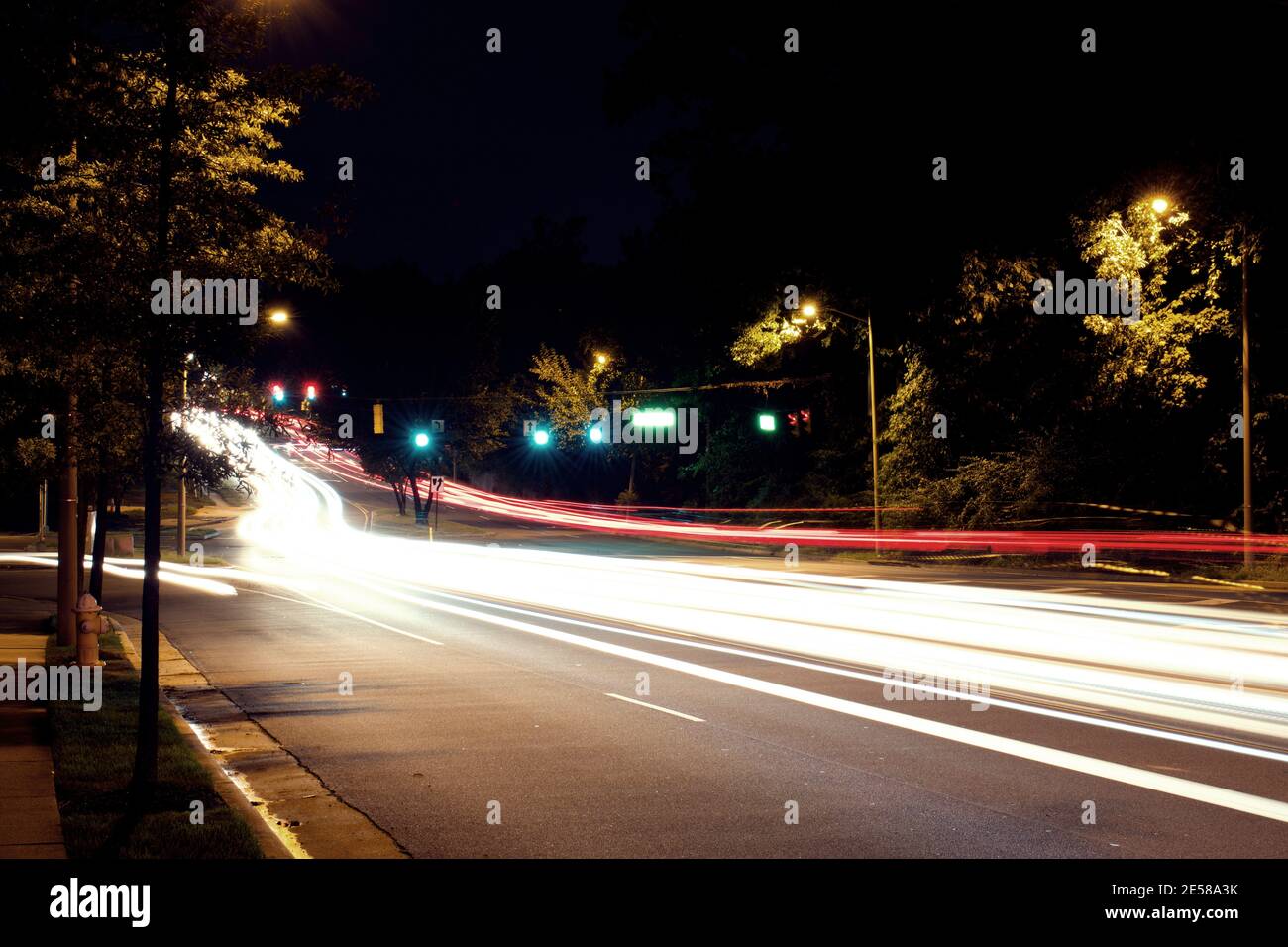 Light Trails from car traffic, headlights, and brake lights, along city roads at night. Stock Photo