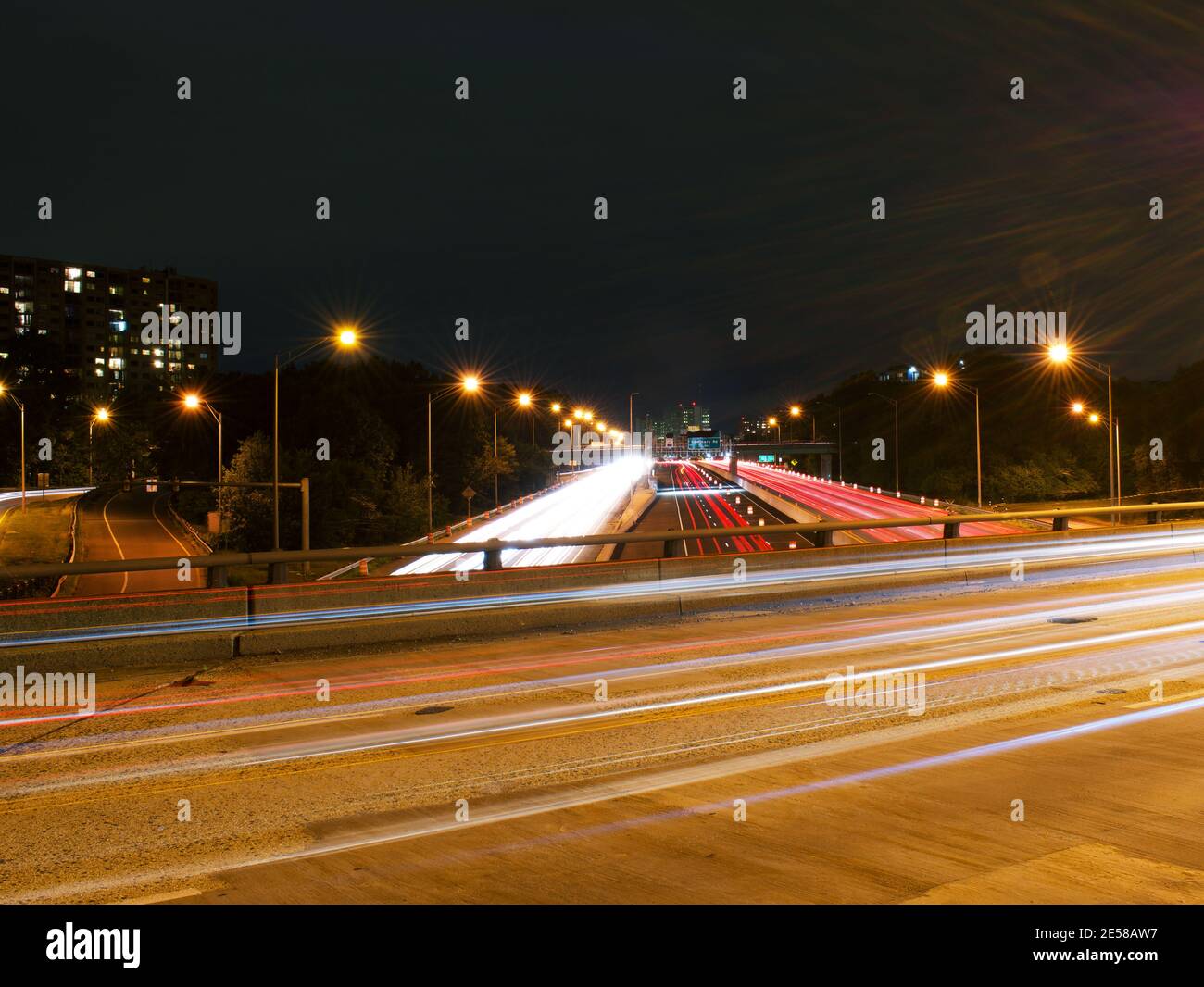 Light trails from vehicles traveling on the interstate 395,  view of the highway from overpass road. Stock Photo