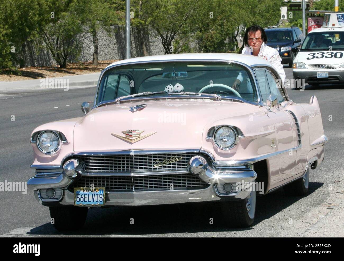 Exclusive!! The King takes some time out from eternity to help out with a wedding on the Las Vegas Strip. This Elvis impersonator takes his craft seriously, right down to his 1956 Cadillac with a 56ELVIS license plate. Las Vegas, NV. 9/12/07.   [[tag]] Stock Photo