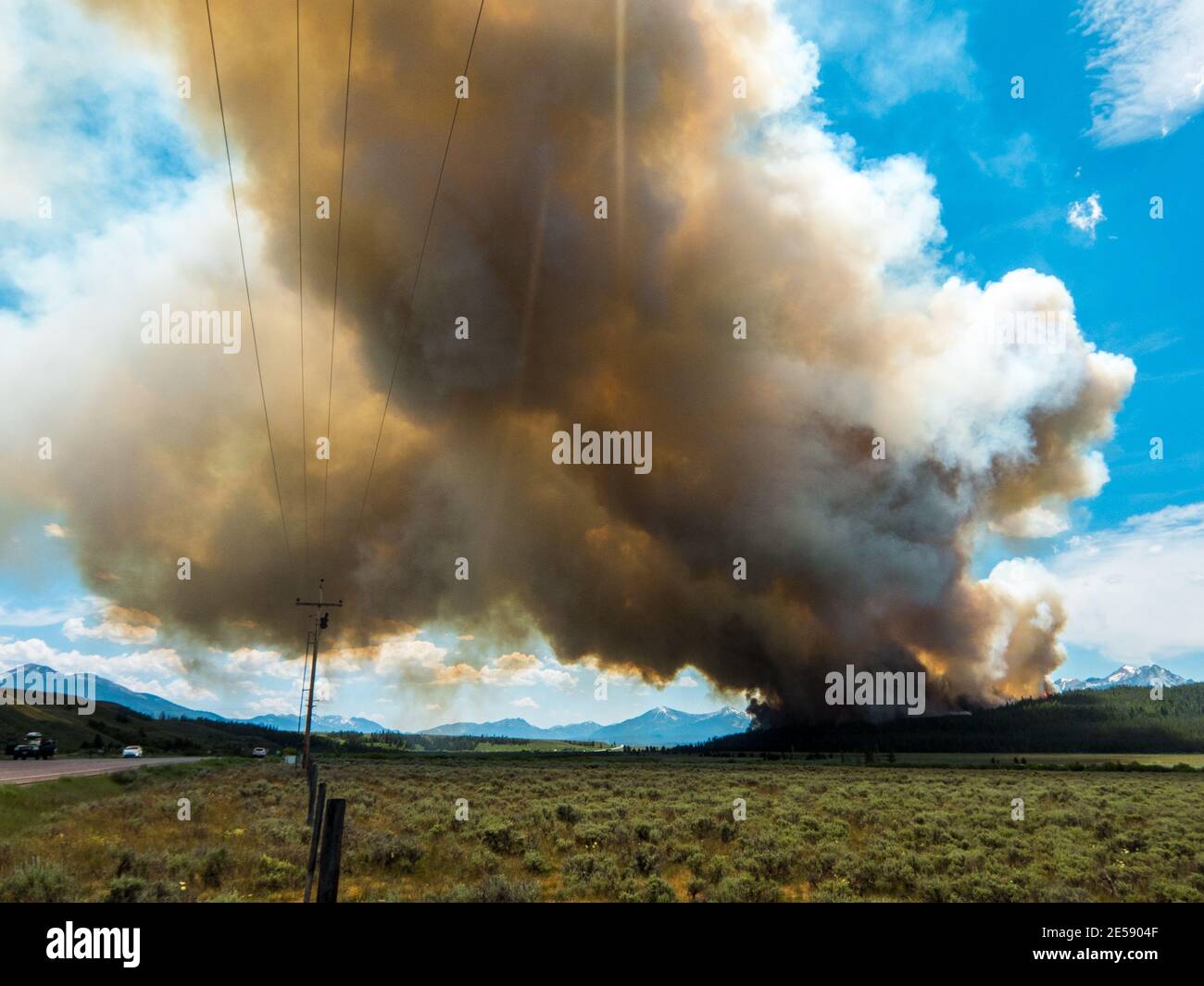 Forest fire burning near the Hell Roaring Lake trail in the Sawtooth National Forest sends plume of smoke across Highway 78 south of Stanley, Idaho Stock Photo