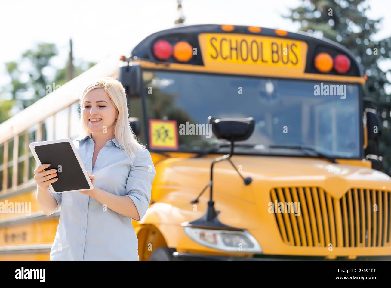 Teacher at school in front of the bus Stock Photo - Alamy