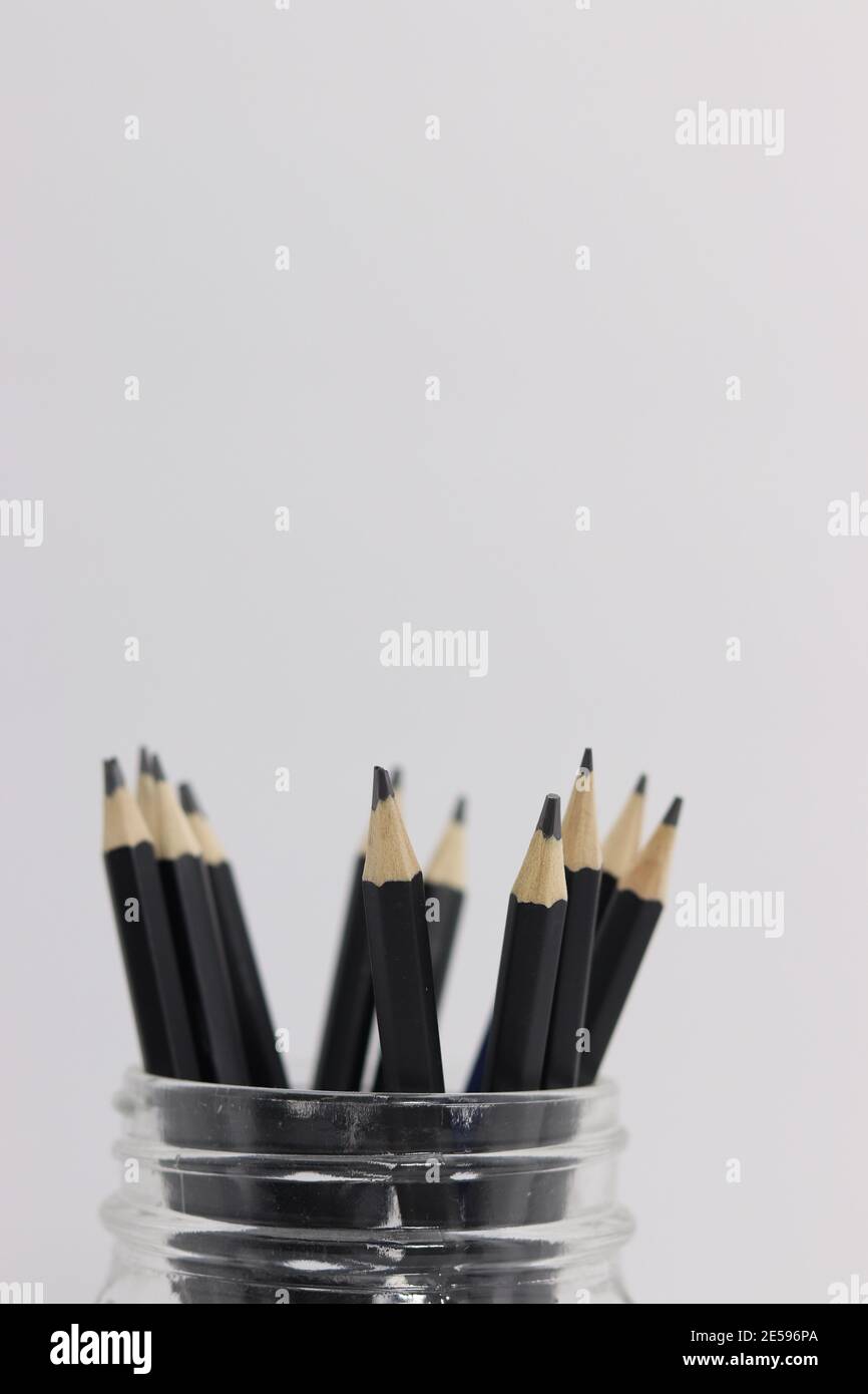 A glass cup full of drawing pencils Stock Photo