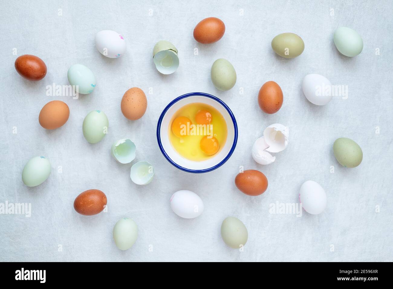 Different types of free range eggs with raw eggs in a bowl and shells on a white background Stock Photo