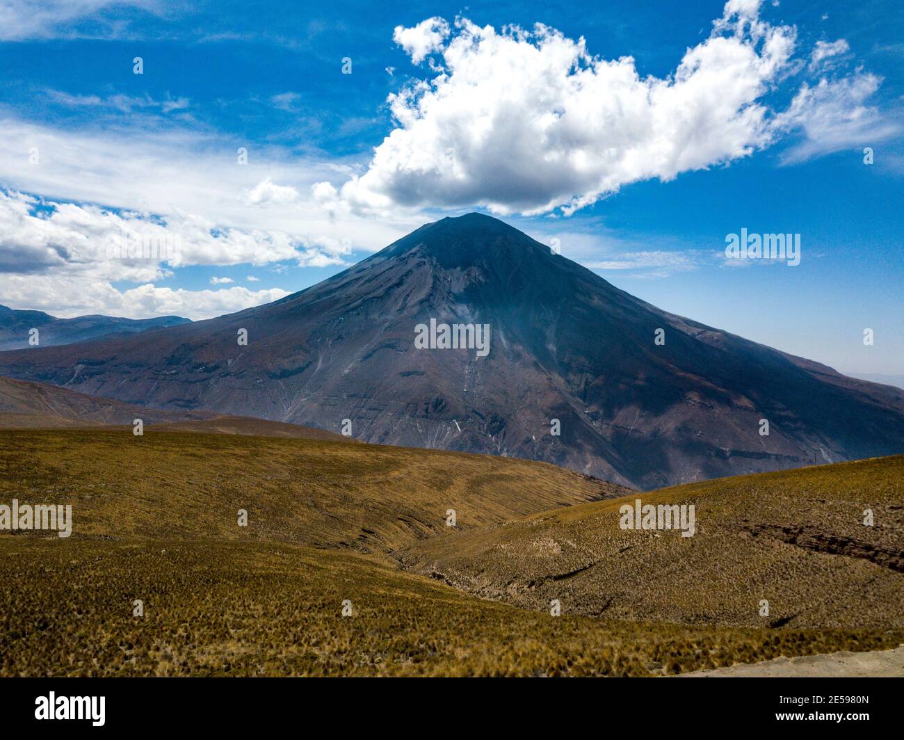 A view at the back of the Misti volcano y Arequipa, Peru in a sunny day. The dry and inhabited land can be seen in the sceene. Stock Photo