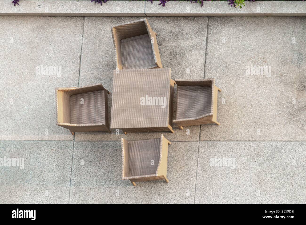 Four seaters outdoor patio set on a washed sand open-air patio, top view Stock Photo