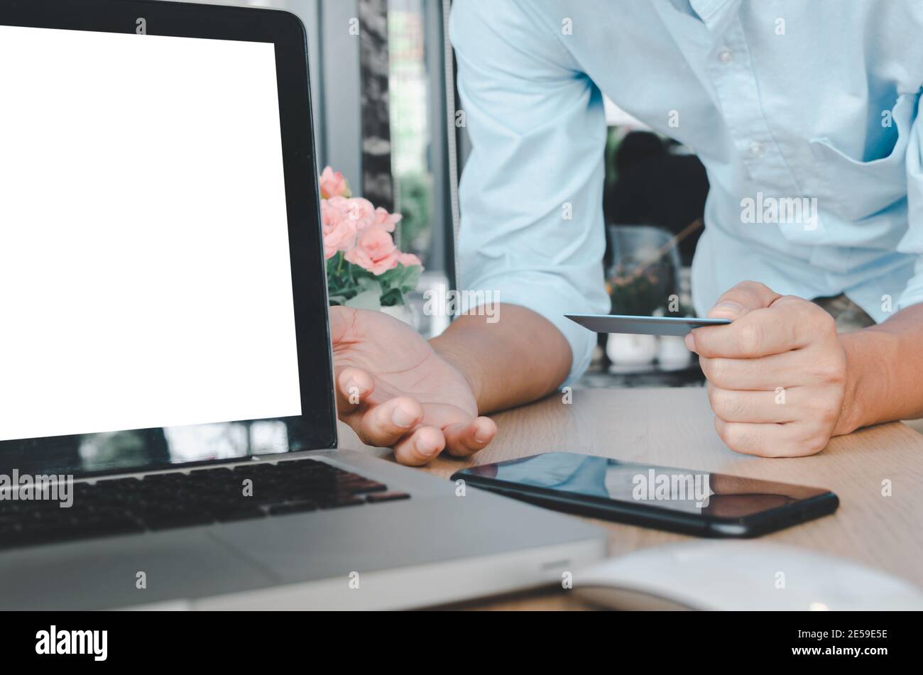 business man hand holding credit card  with computer laptop on table.Shop online and make payment transactions business concept Stock Photo
