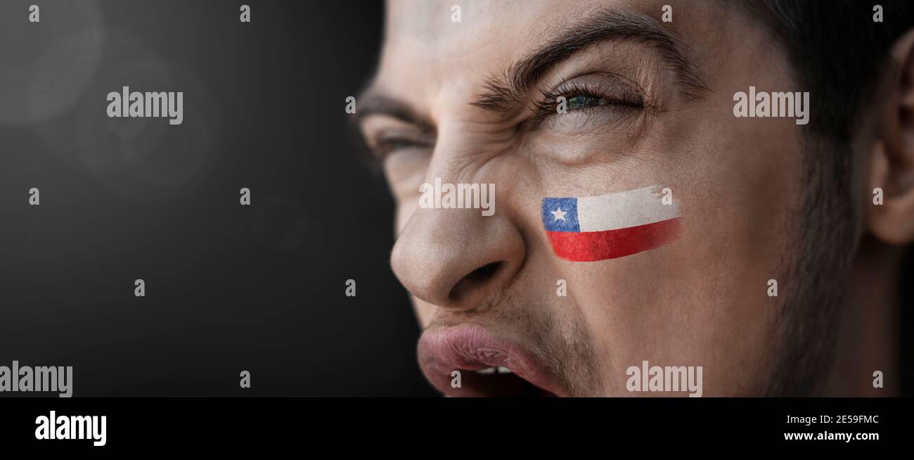 A screaming man with the image of the Chile national flag on his face Stock Photo