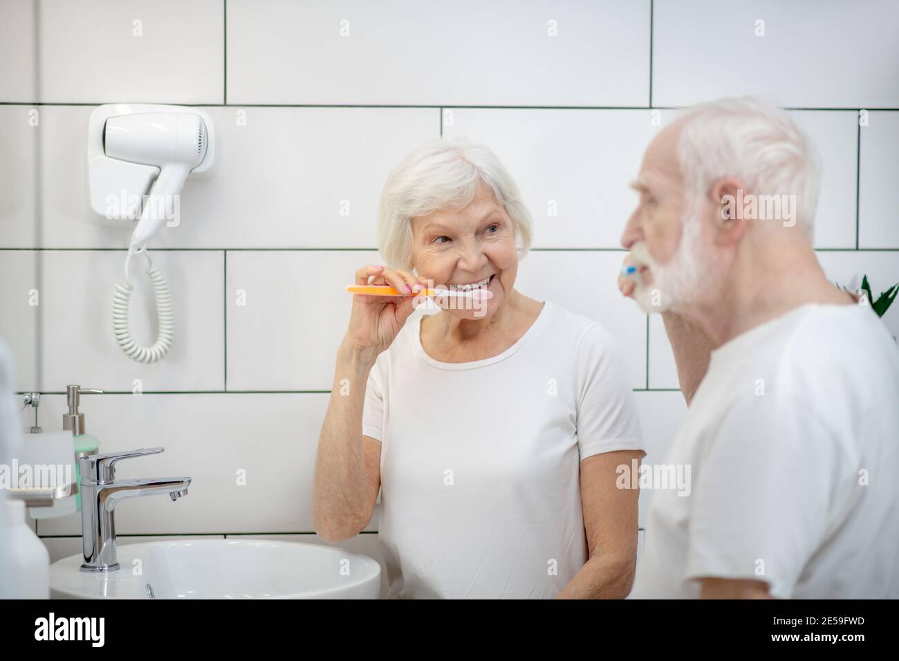 Elderly couple brushing their teeth together and feeling good Stock Photo