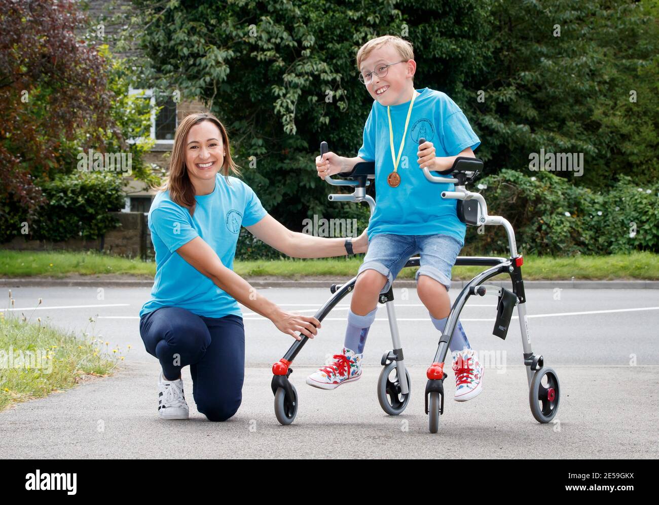 File photo dated 01/08/2020 of Tobias Weller, who has cerebral palsy and autism, alongside Olympic athlete Jessica Ennis-Hill, after he completed his challenge to run a marathon in a street near his home in Sheffield, using a race runner. Tobias, who cannot stand or walk unaided, was inspired by Captain Tom Moore to complete his first marathon on his daily walks back in April. Saturday January 30 marks the one year anniversary of the earliest known death from coronavirus in UK. Issue date: Wednesday January 27, 2021. Stock Photo