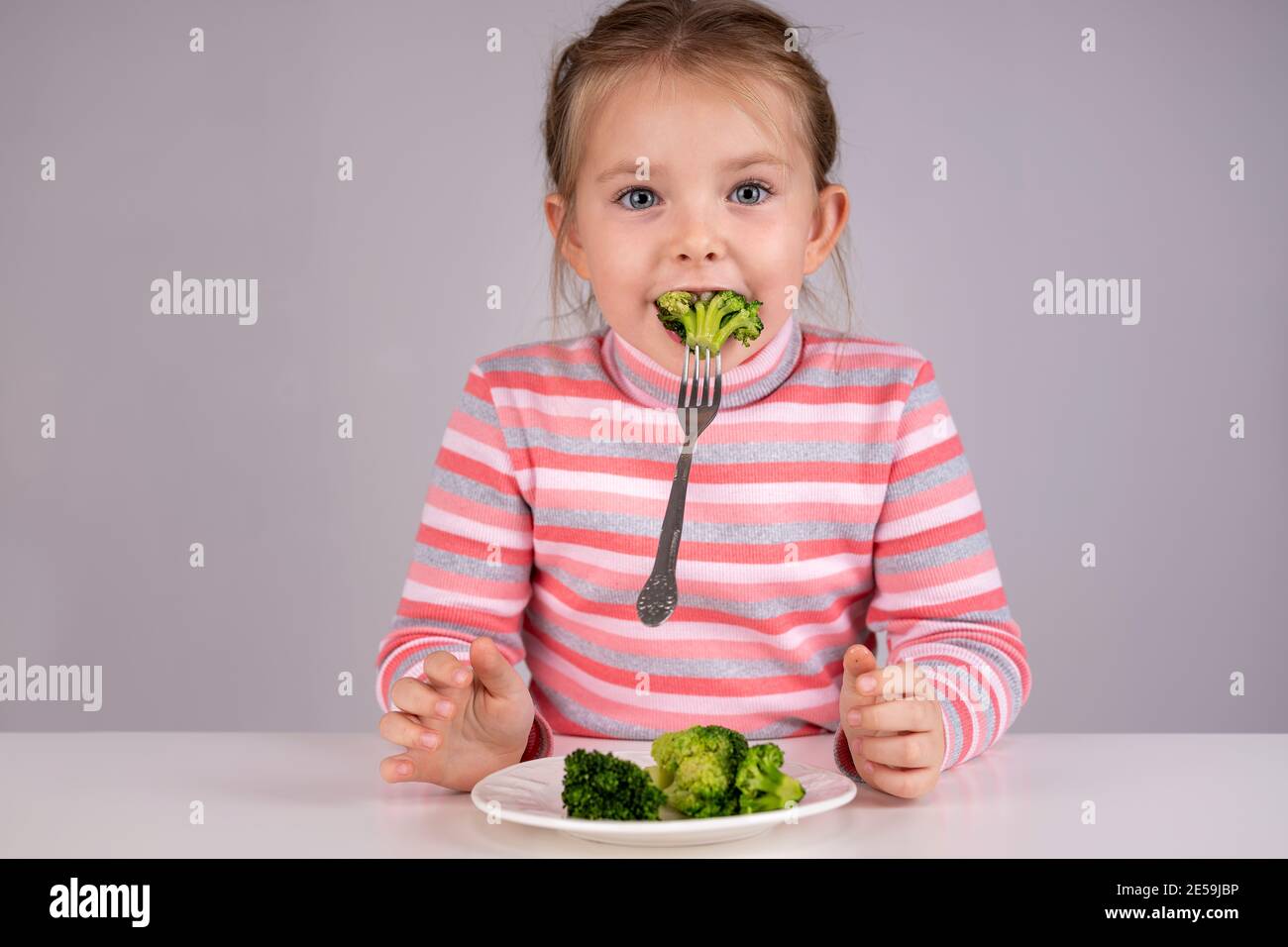 Child has fun eating broccoli. High quality photo Stock Photo Alamy