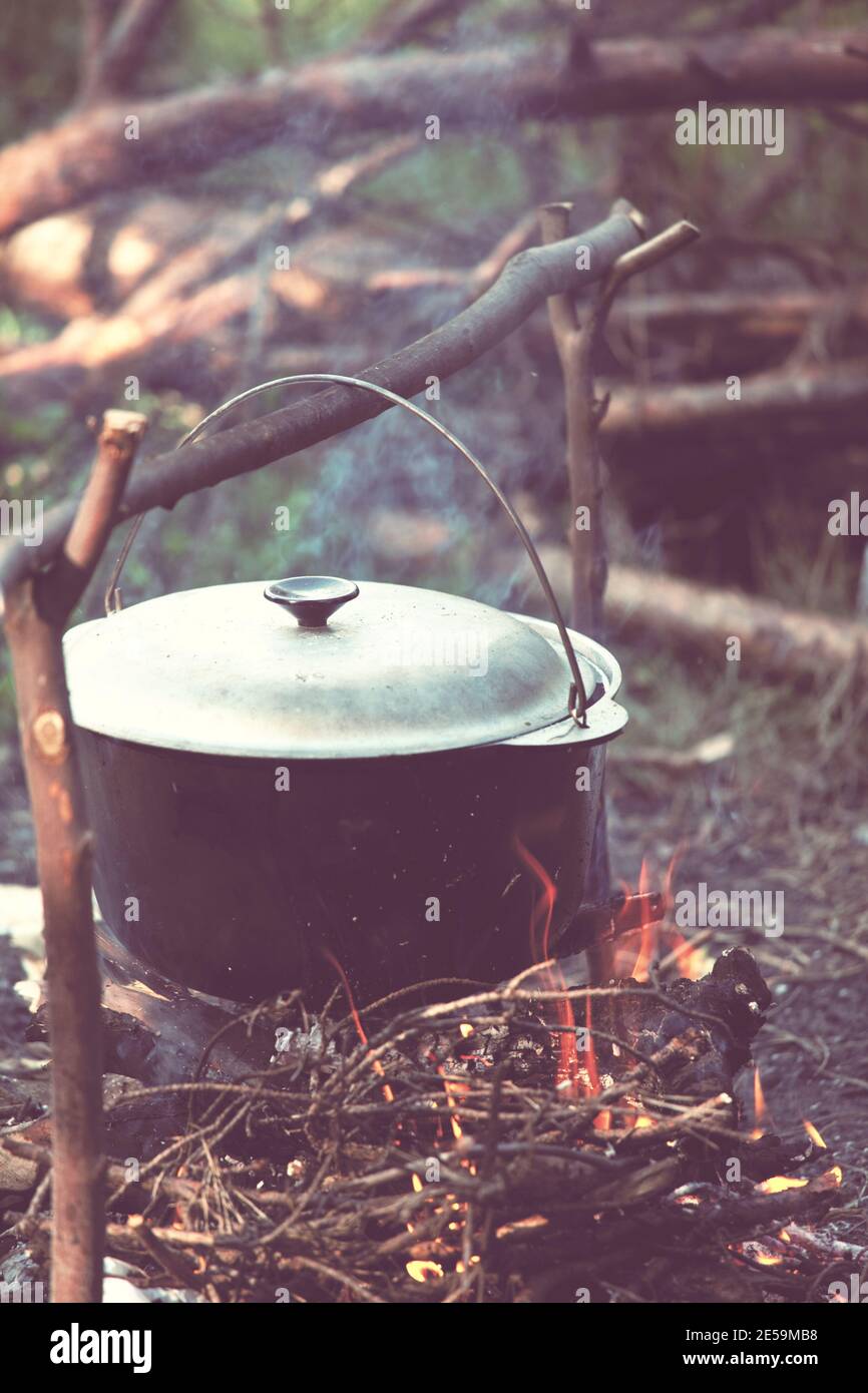 Touristic kettle on fire of burning campfire in camping in the hike ...