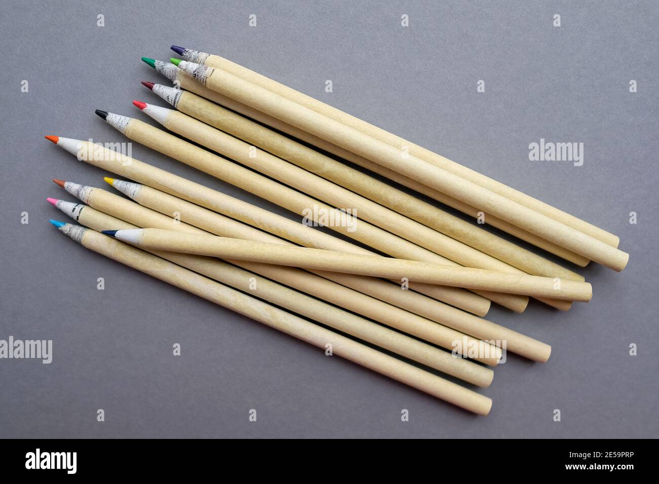 Colored eco-friendly pencils on gray background. Multiple stationery. Stock Photo