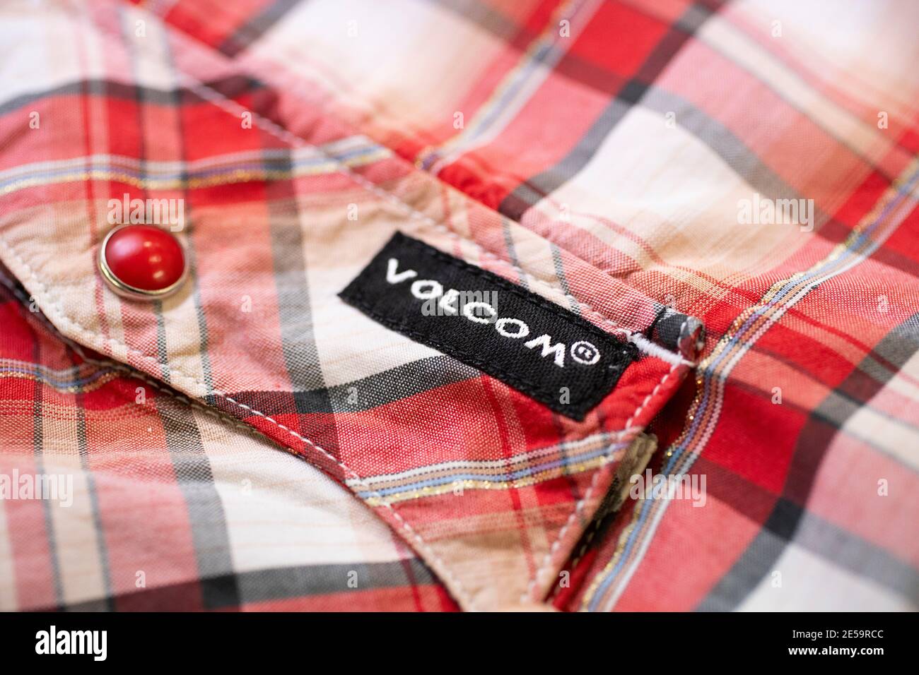 A red checked Volcom shirt on a white wooden background Stock Photo