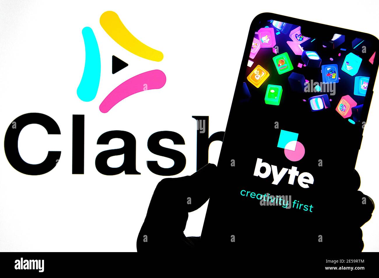 BYTE app logo seen on the silhouette of smartphone screen and blurred background with Clash app logo. Concept for merger. Popular short video platform Stock Photo