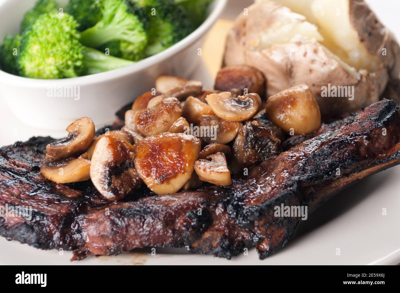 rib steak grilled to perfection with mushrooms, brocolli and bak Stock Photo