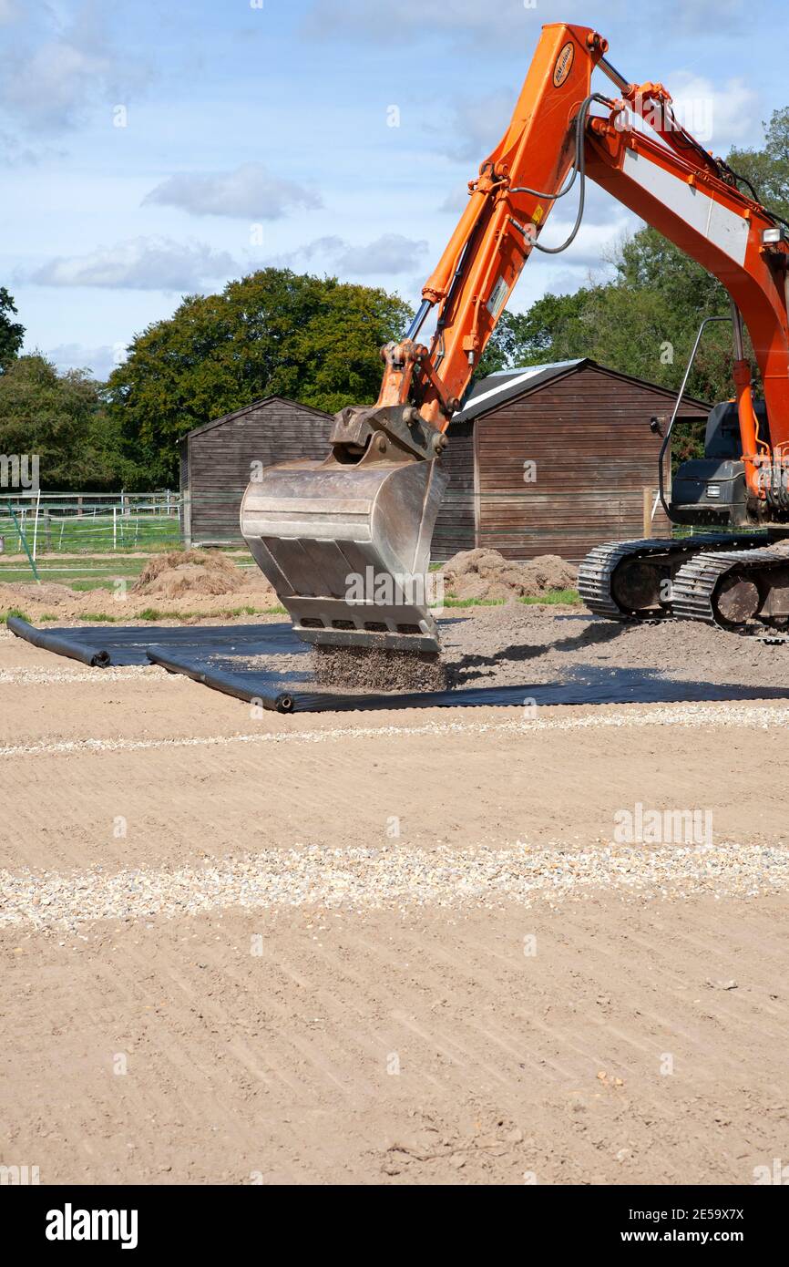 Excavator working on the construction of a riding arena Stock Photo