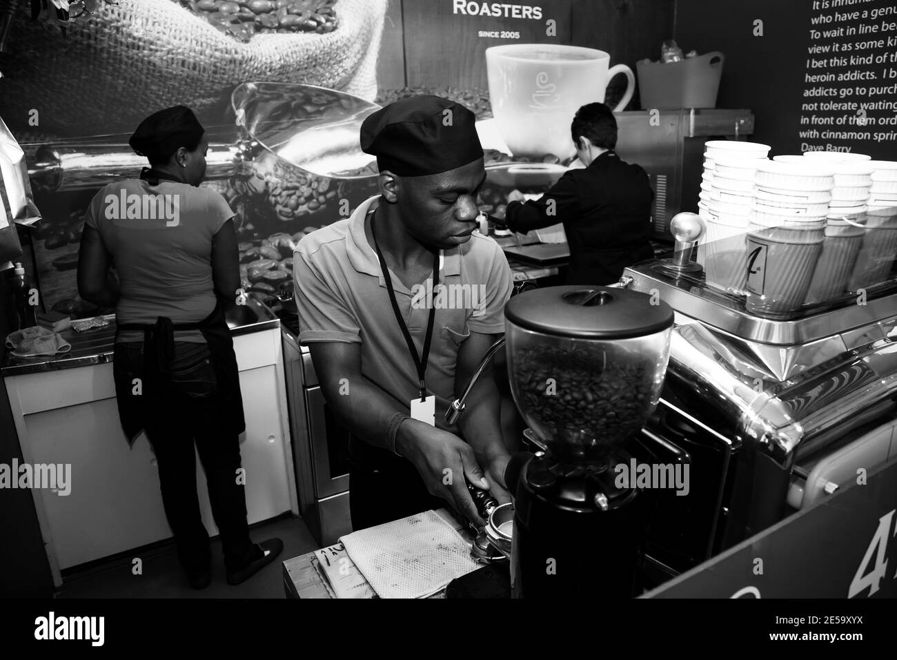 JOHANNESBURG, SOUTH AFRICA - Jan 05, 2021: Johannesburg, South Africa - November 24 2012: African Male barista making a coffee at a food festival vend Stock Photo