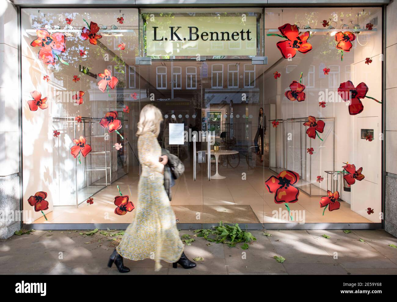 A woman walks past an empty LK Bennett store which has been closed since March 2020 and is struggling financially due to the Coronavirus pandemic and lockdown, Kings Road, London. Stock Photo