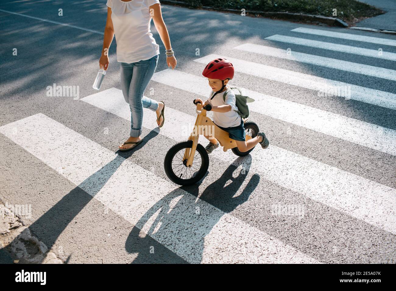 Young boy on bike crossing road at zebra crossing. Stock Photo