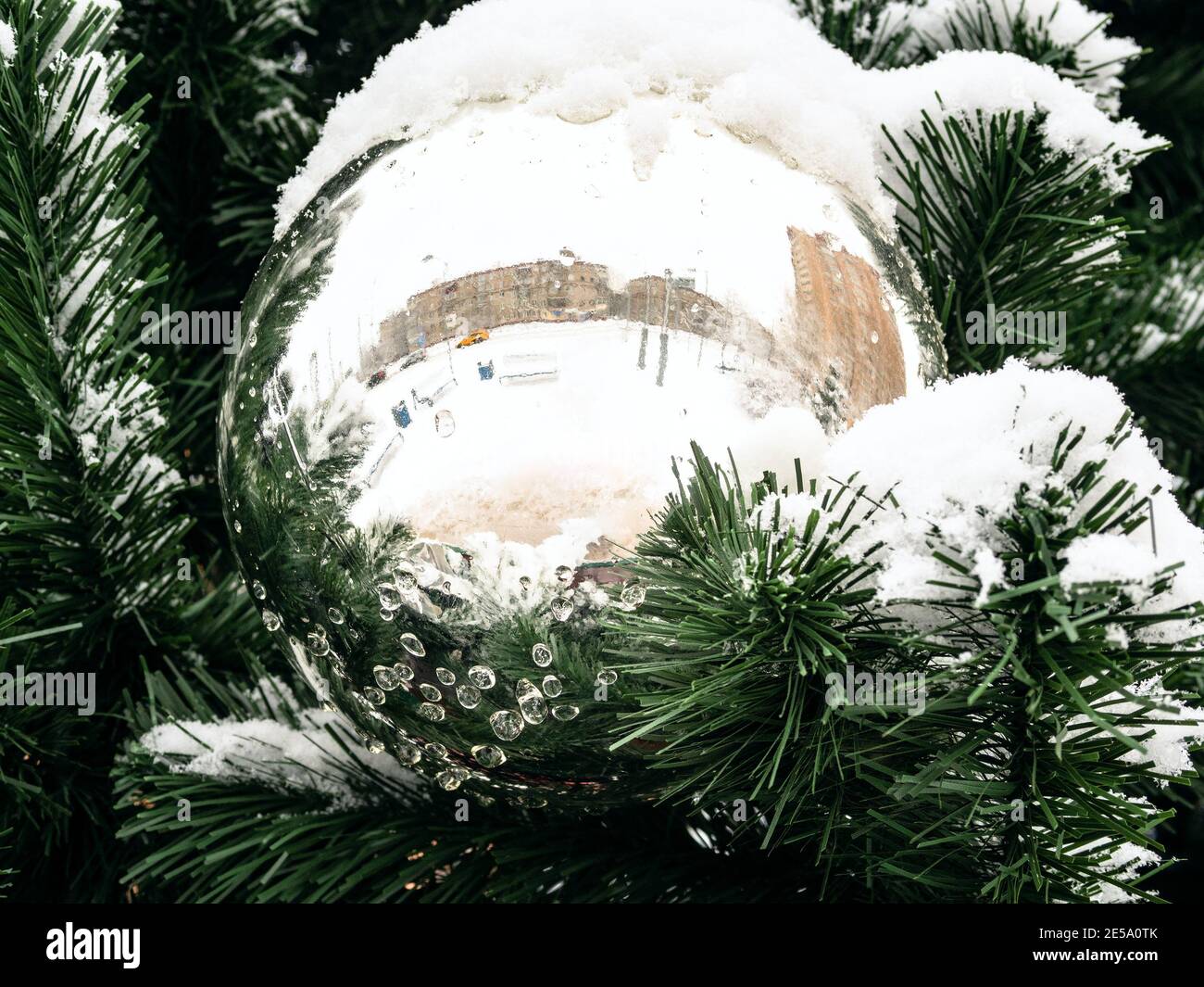 mirrored ball on outdoor Christmas tree close up on overcast winter day Stock Photo