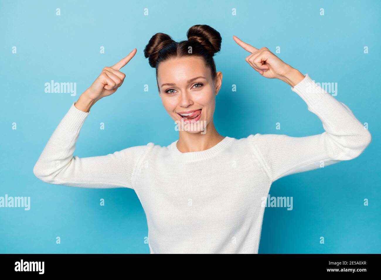 Photo of funny girl indicate fingers two buns tongue-out wear white ...