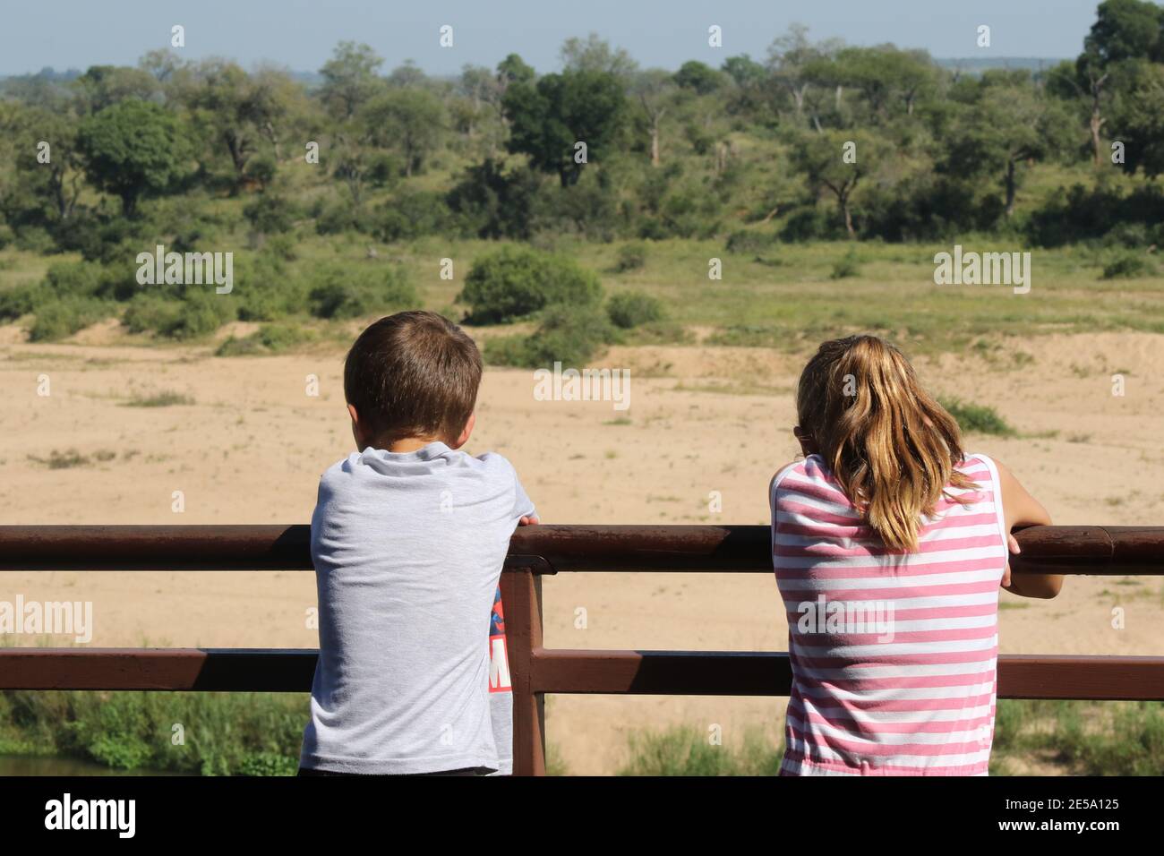 Two children looking out over the mighty Crocodile River, South Africa Stock Photo