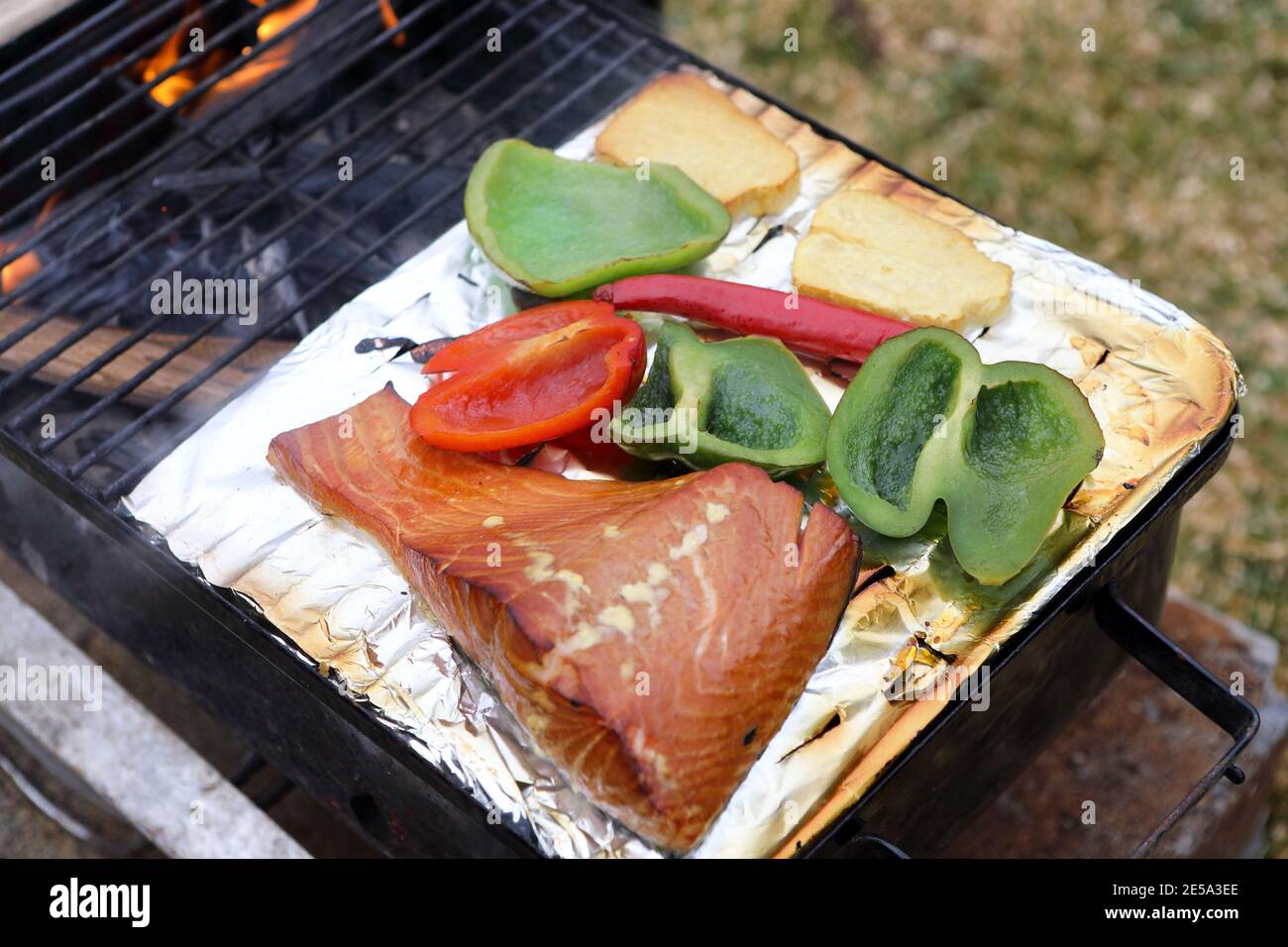 Smoking salmon, peppers, chilli and cheese on a BBQ Stock Photo