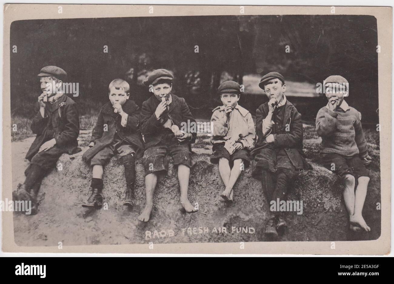 Royal Antidiluvian Order of Buffaloes (RAOB) Fresh Air Fund: inner city children enjoying sweets on a trip to the countryside, early 20th century Britain Stock Photo