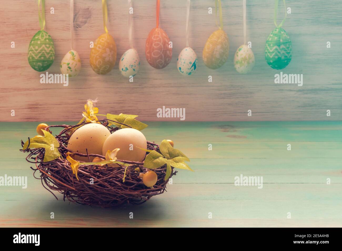 Easter rabbits toys, row of hanging eggs on vintage wood background. Funny Easter decoration with copy space. Easter mood. Stock Photo
