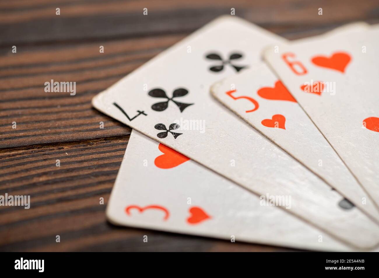 Playing cards on a wooden table. Close-up, selective focus. Stock Photo