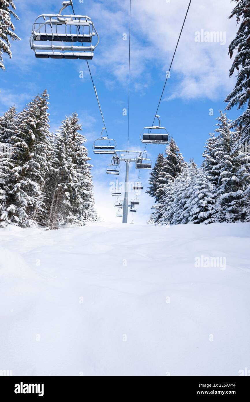 unused chairlifts in the fresh snow with blue skies winter 2020/21 Stock Photo