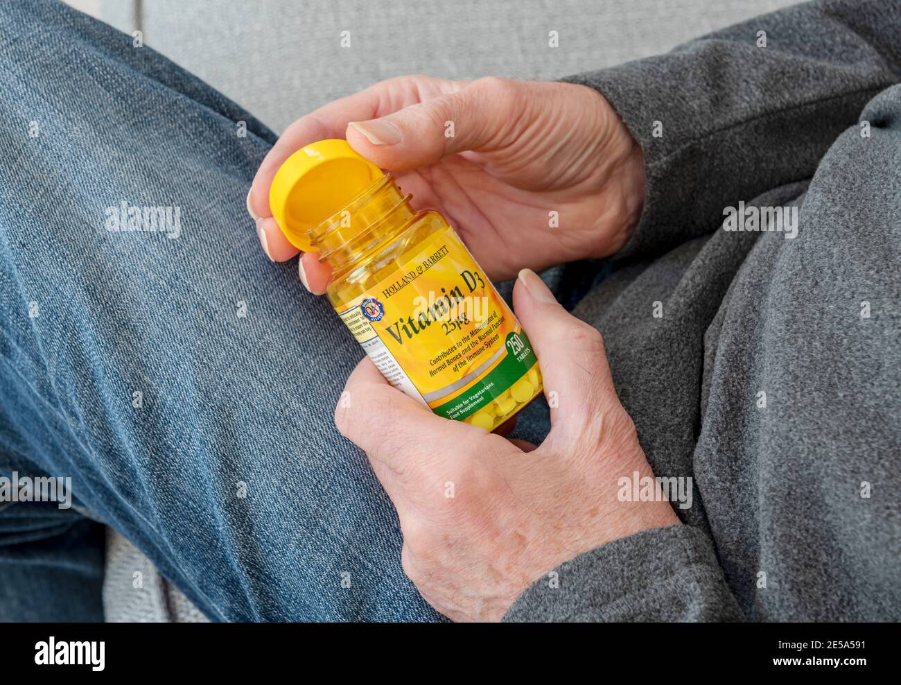 Close up of man holding plastic bottle of Vitamin D tablets supplement Stock Photo