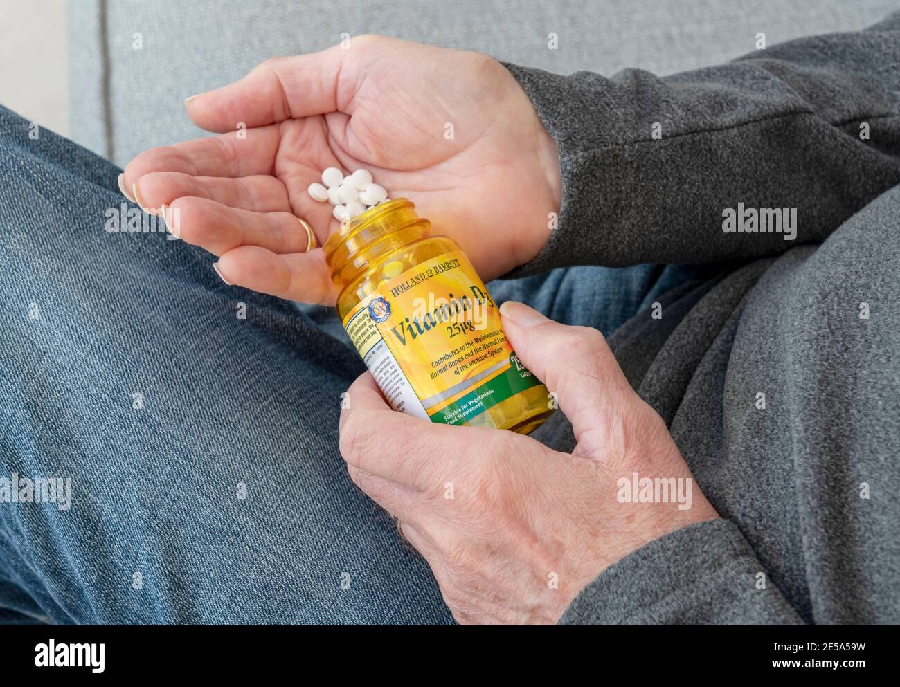 Close up of man holding plastic bottle of Vitamin D tablets supplement tablet Stock Photo