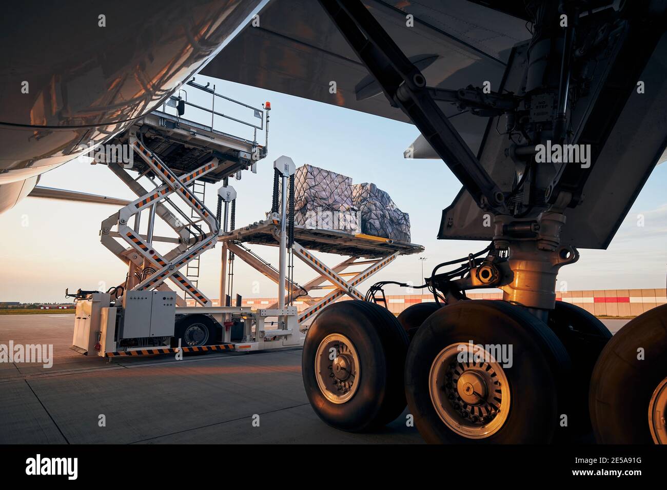 Loading of cargo containers to plane at airport. Ground handling preparing freight airplane before flight. Stock Photo