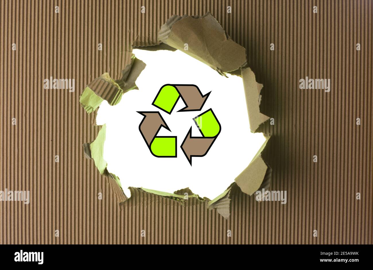 Ripped brown paper with recycle logo against background Stock Photo